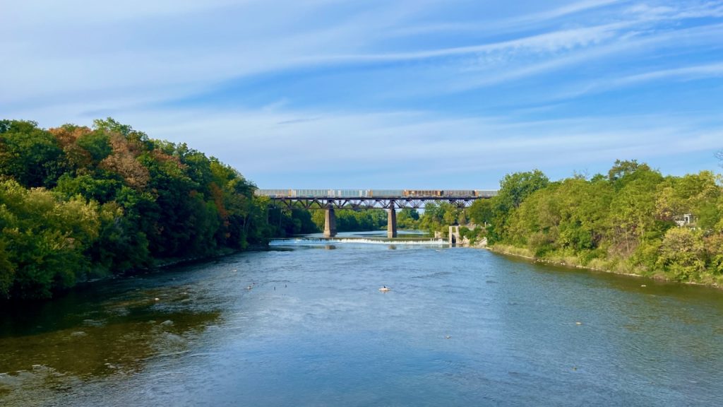 Photo of the Grand River in Paris, Ontario, with the 760 foot-long Paris Railway Bridge in the distance.